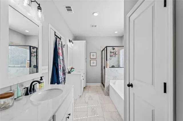 a bathroom with a double vanity sink mirror and shower