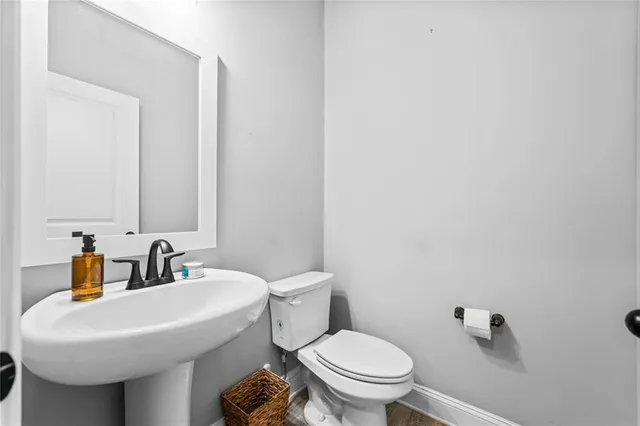 a bathroom with a sink a toilet and mirror