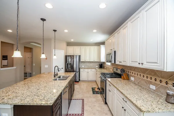 a kitchen with stainless steel appliances granite countertop a sink stove and refrigerator
