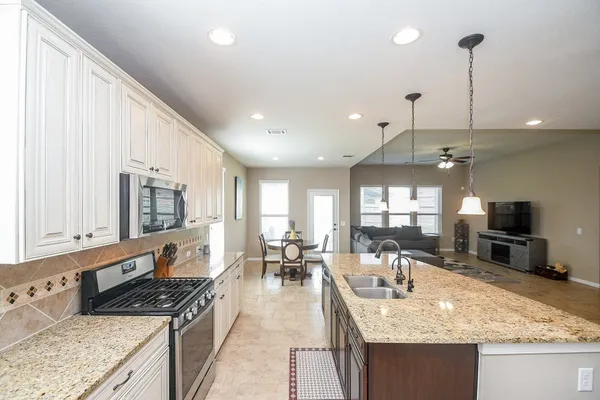a kitchen with stainless steel appliances granite countertop a sink stove and refrigerator