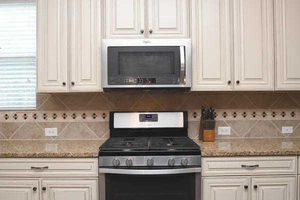 a stove top oven sitting inside of a kitchen