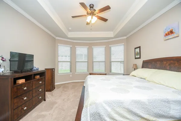 a spacious bedroom with a bed and a ceiling fan