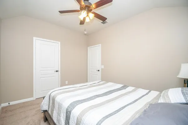 a bedroom with a bed and a chandelier fan