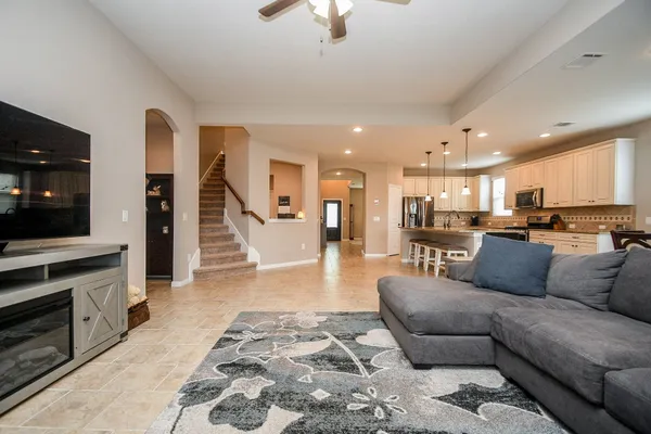 a living room with furniture and a view of kitchen