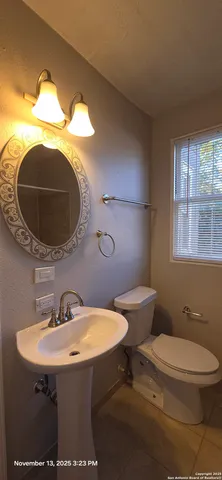 a bathroom with a toilet sink and mirror
