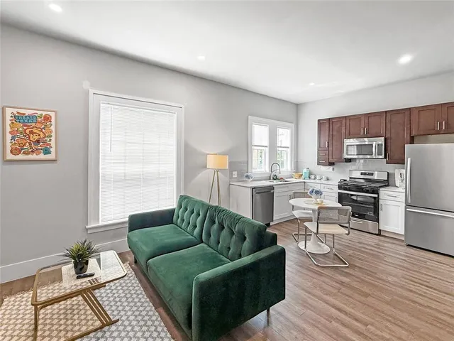 a living room with furniture and a dining table with kitchen view