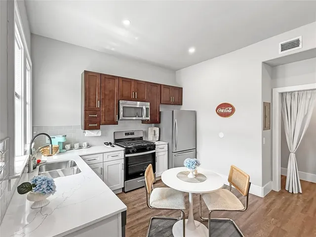a kitchen with a sink a stove and chairs