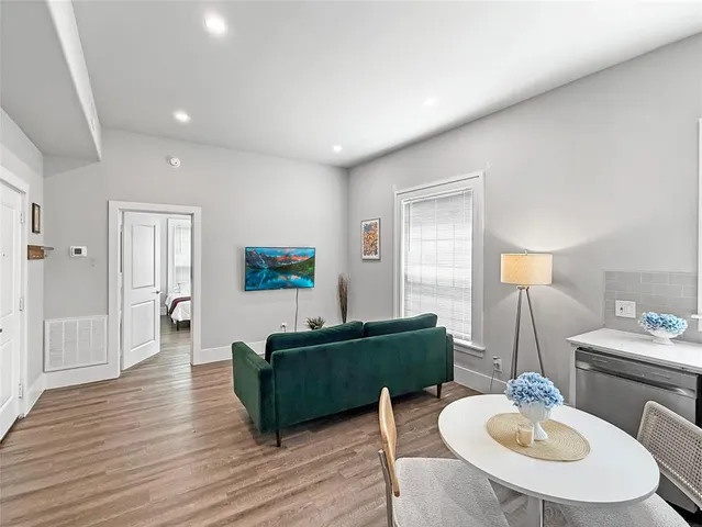 a living room with furniture and a wooden floor