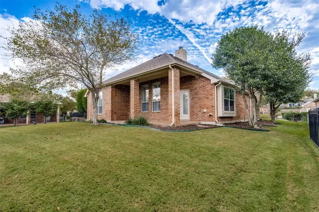a front view of a house with a garden and trees