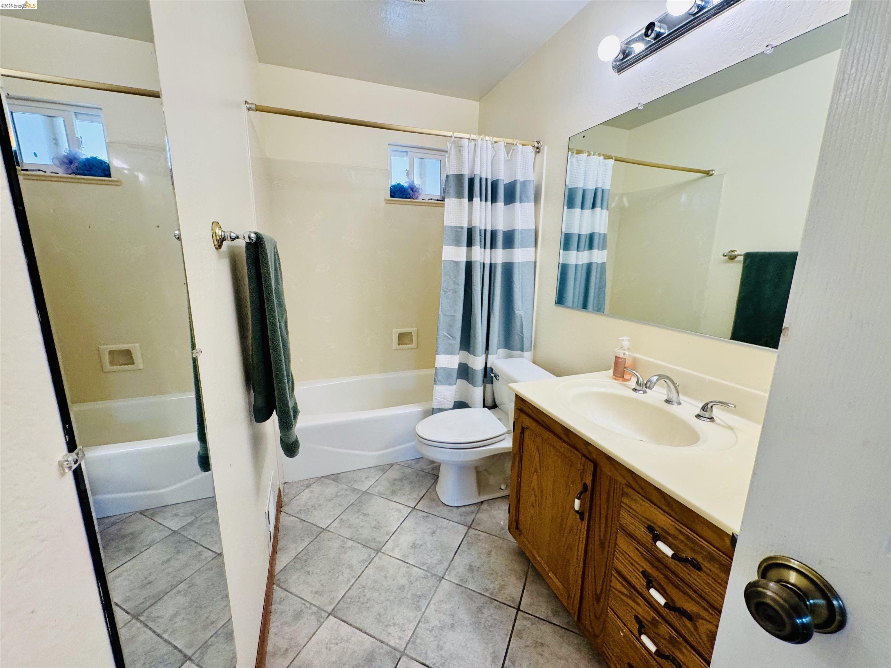 3513 Rio Grande Drive Antioch, CA 94509 - Photo 13 of 22 Full bathroom featuring a single vanity with wood-finish cabinetry, a white countertop, and a chrome faucet