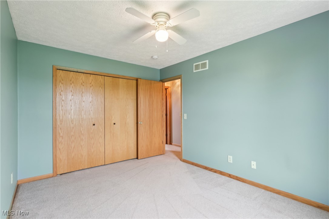 108 Joshua Drive Rittman, OH 44270 - Photo 24 of 44 Unfurnished bedroom with baseboards, light carpet, a closet, ceiling fan, and a textured ceiling