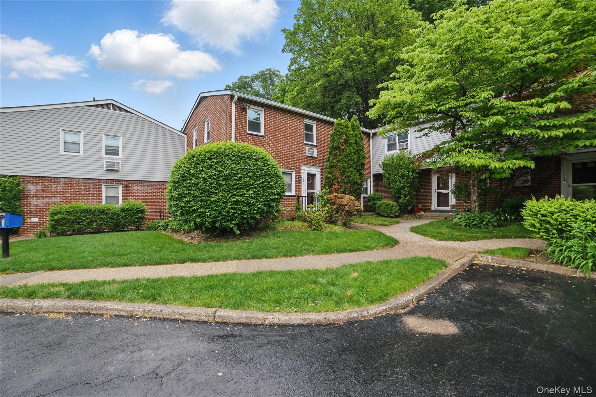 147 Charter Circle, Unit 147 Ossining, NY 10562 - Photo 1 of 1 a view of a white house with a big yard and potted plants