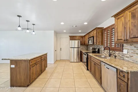 a large kitchen with stainless steel appliances granite countertop a sink and cabinets
