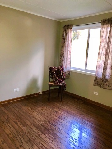 1102 Springinsguth Road, Unit 1A Schaumburg, IL 60193 - Photo 9 of 14 a view of room with hardwood floor and window