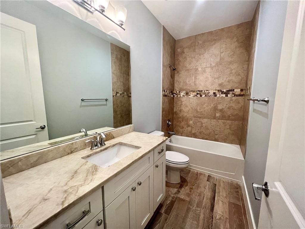 3128 Woodside Avenue Naples, FL 34112 - Photo 13 of 16 a bathroom with a granite countertop sink toilet and shower
