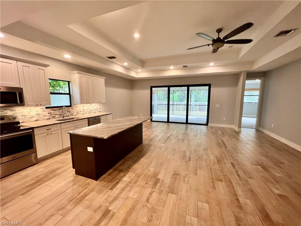 3128 Woodside Avenue Naples, FL 34112 - Photo 4 of 16 a large kitchen with kitchen island a counter top space a sink stainless steel appliances and cabinets