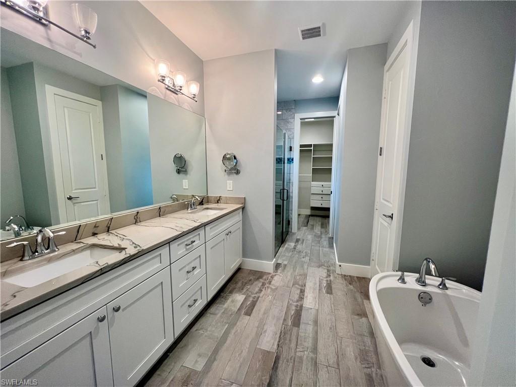 3128 Woodside Avenue Naples, FL 34112 - Photo 8 of 16 a spacious bathroom with a granite countertop sink mirror and a bathtub