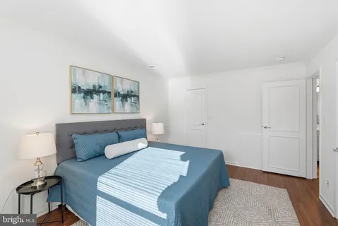 a bedroom with a bed and a painting on the wall