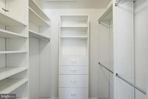 a view of walk in closet with empty racks