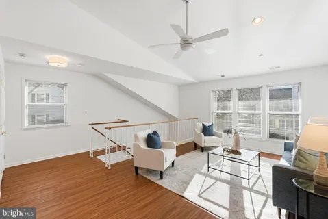 a living room with couches a coffee table and a large window with wooden floor