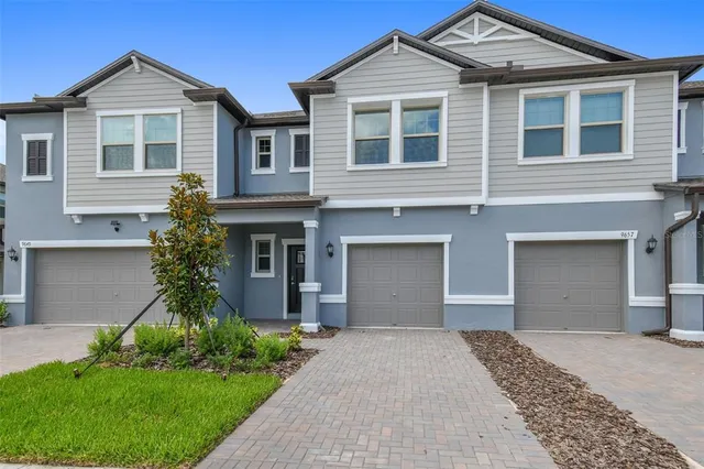 a front view of a house with a yard and garage