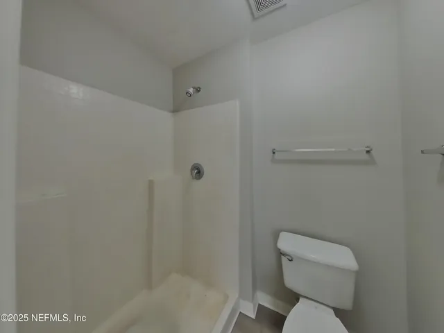 a white toilet sitting next to a bath tub