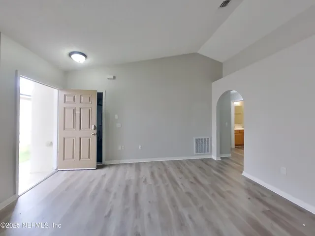 a view of empty room with wooden floor