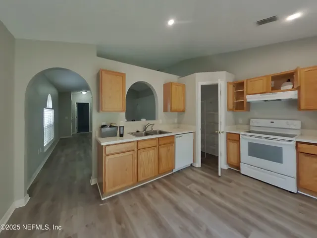 a kitchen with stainless steel appliances granite countertop a stove a sink and a microwave