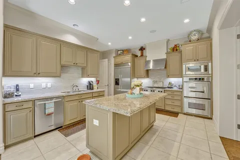a kitchen with stainless steel appliances granite countertop a sink counter space cabinets and a large window