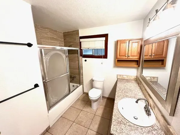 a kitchen with stainless steel appliances granite countertop wooden floors wooden cabinets a stove top oven