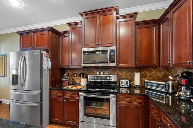 a kitchen with stainless steel appliances granite countertop a refrigerator stove and sink