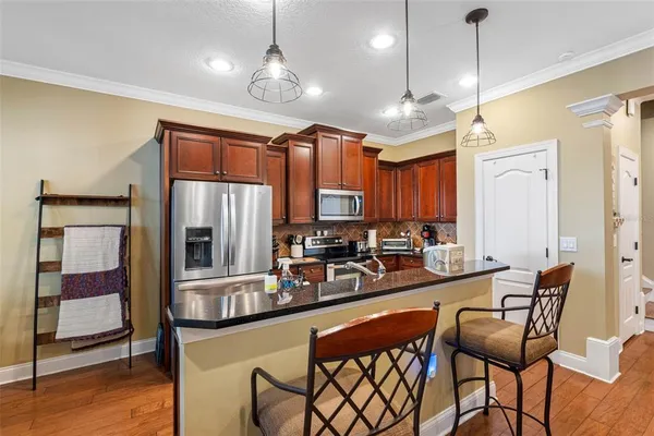 a kitchen with stainless steel appliances granite countertop a sink a stove and a refrigerator