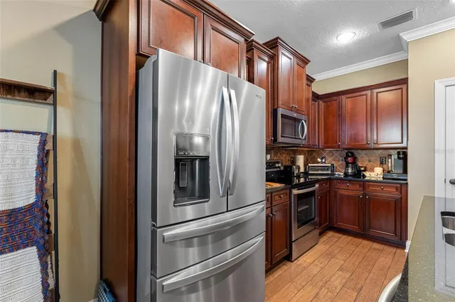 a kitchen with stainless steel appliances granite countertop a refrigerator and a stove top oven