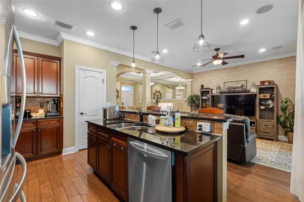 a kitchen with stainless steel appliances granite countertop a sink a stove and a refrigerator