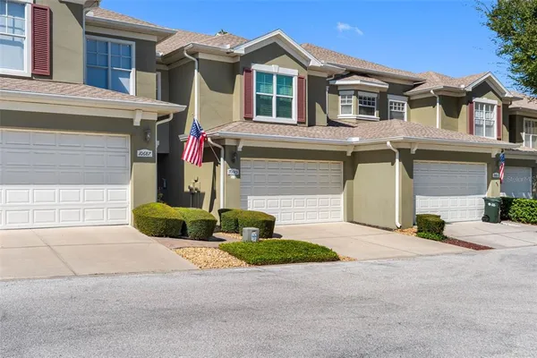 a front view of a house with yard and parking
