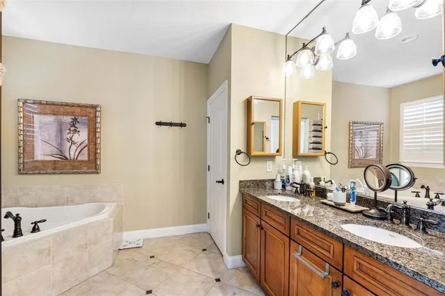 a bathroom with a tub sink and mirror