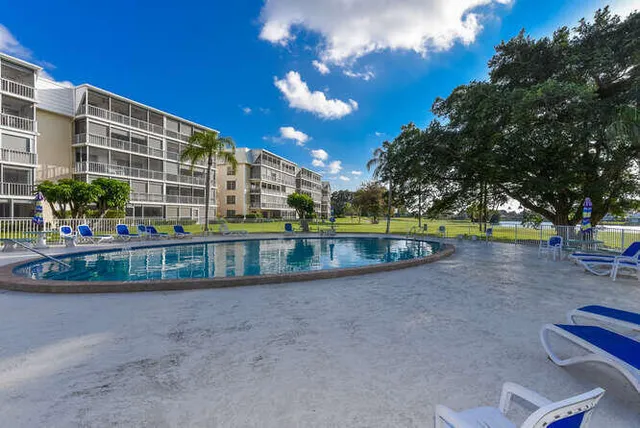 a view of swimming pool with a garden and trees