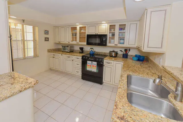 a kitchen with granite countertop a sink and a stove
