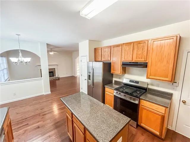 a kitchen with stainless steel appliances granite countertop a stove refrigerator sink and microwave