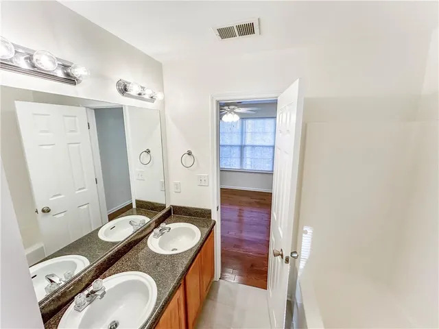 a bathroom with a granite countertop sink and a mirror