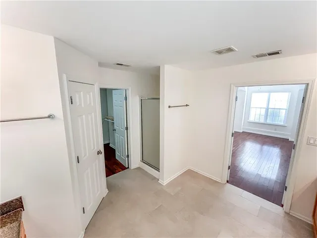 a view of an empty room with closet and a window