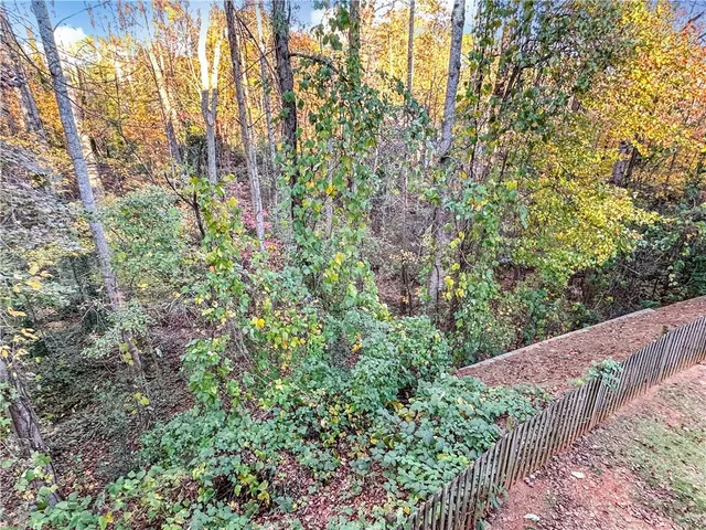 a view of a house with a lush green forest
