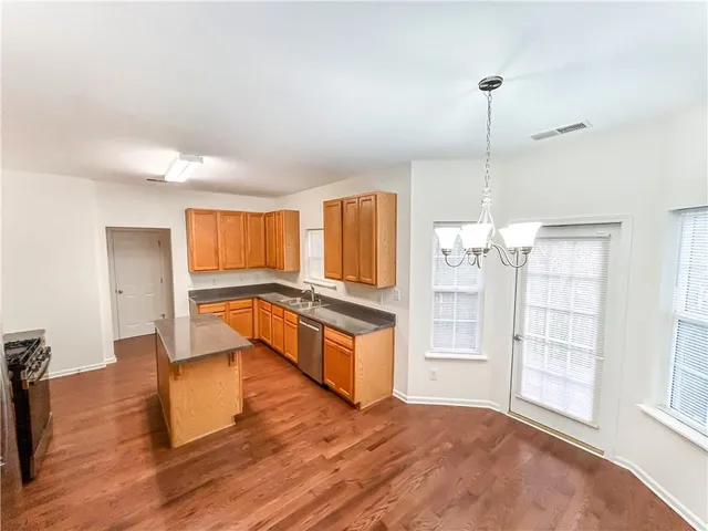 a view of a kitchen with wooden floor and electronic appliances