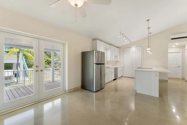 a view of a kitchen with refrigerator and wooden floor