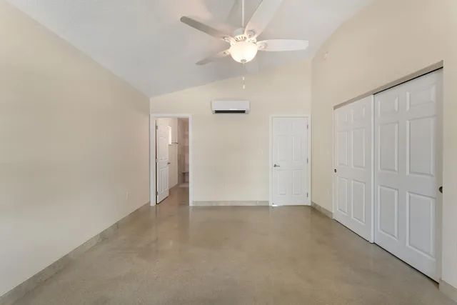 an empty room with a ceiling fan and a window