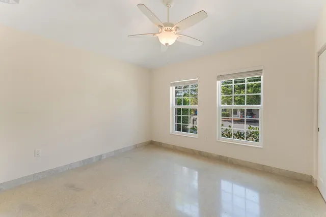 an empty room with a window and a ceiling fan