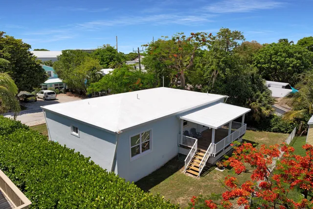 an aerial view of a house with yard and mountain view in back