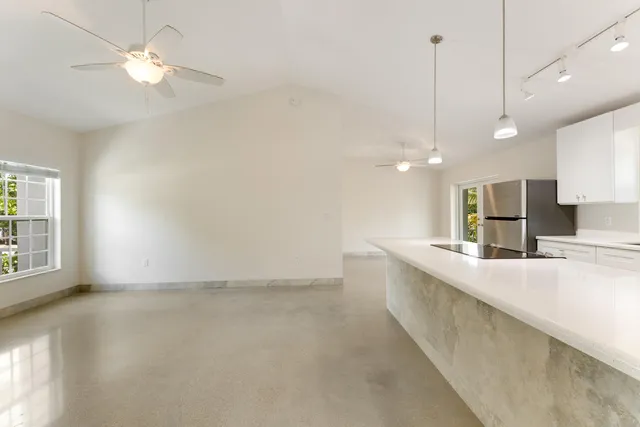 a large kitchen with kitchen island a stove a sink a center island and a chandelier