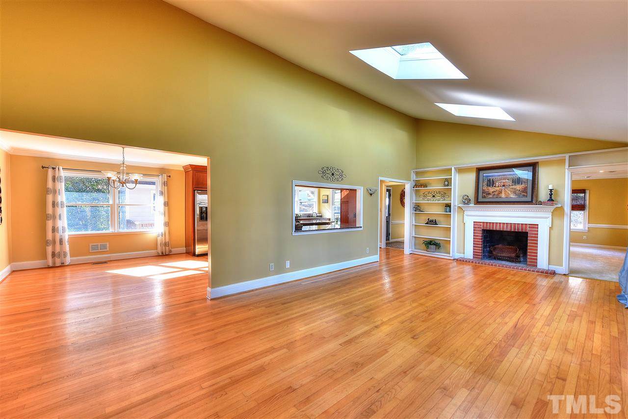 4217 Juniper Street Raleigh, NC 27612 - Photo 8 of 12 a view of empty room with wooden floor and fireplace