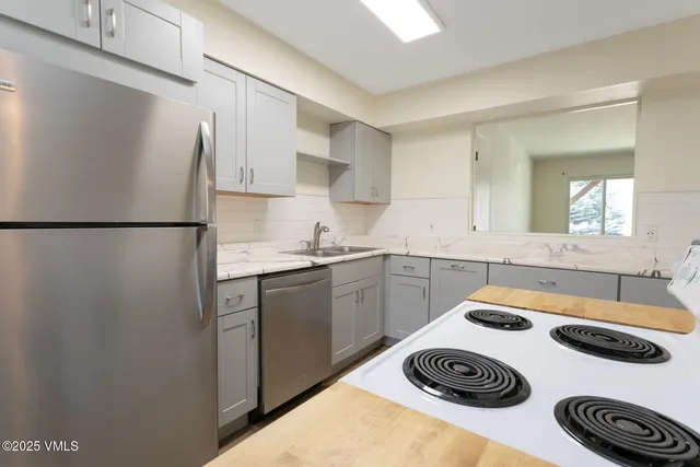 a kitchen with a refrigerator and a sink